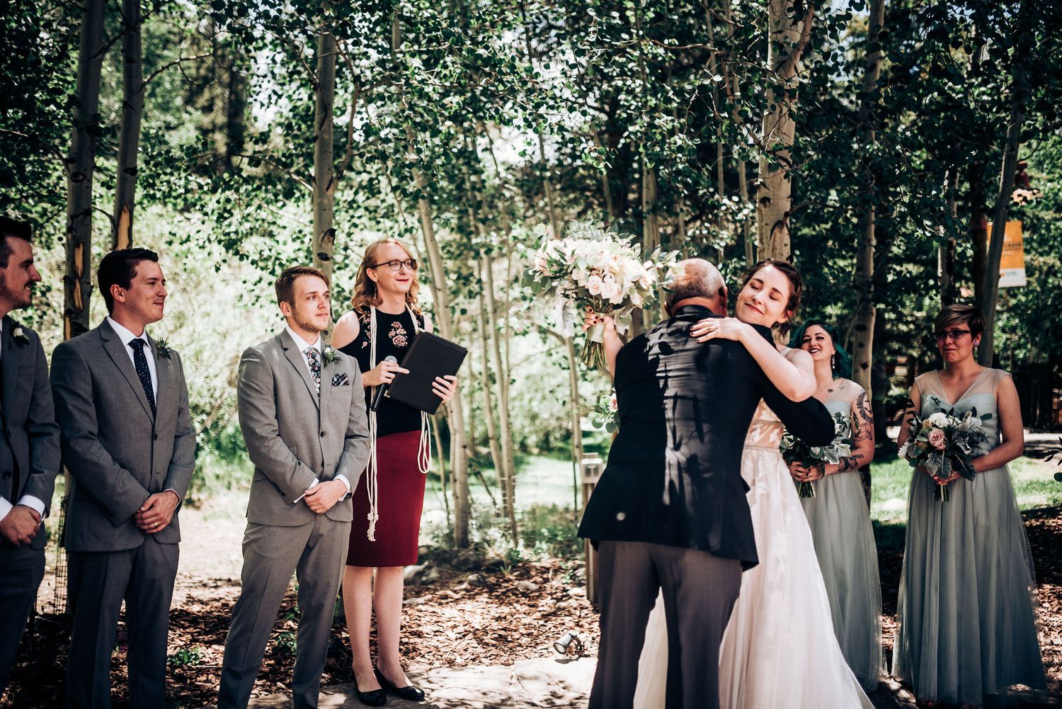 Intimate forest wedding ceremony surrounded by aspen trees.