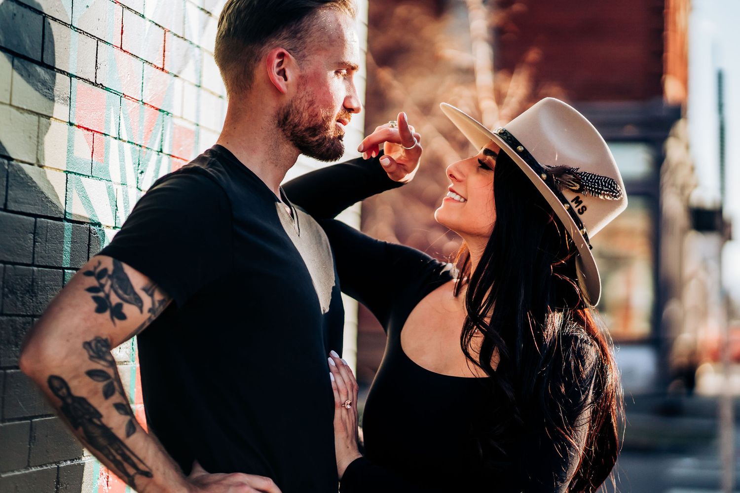 Tender moment captured against brick wall in urban setting.