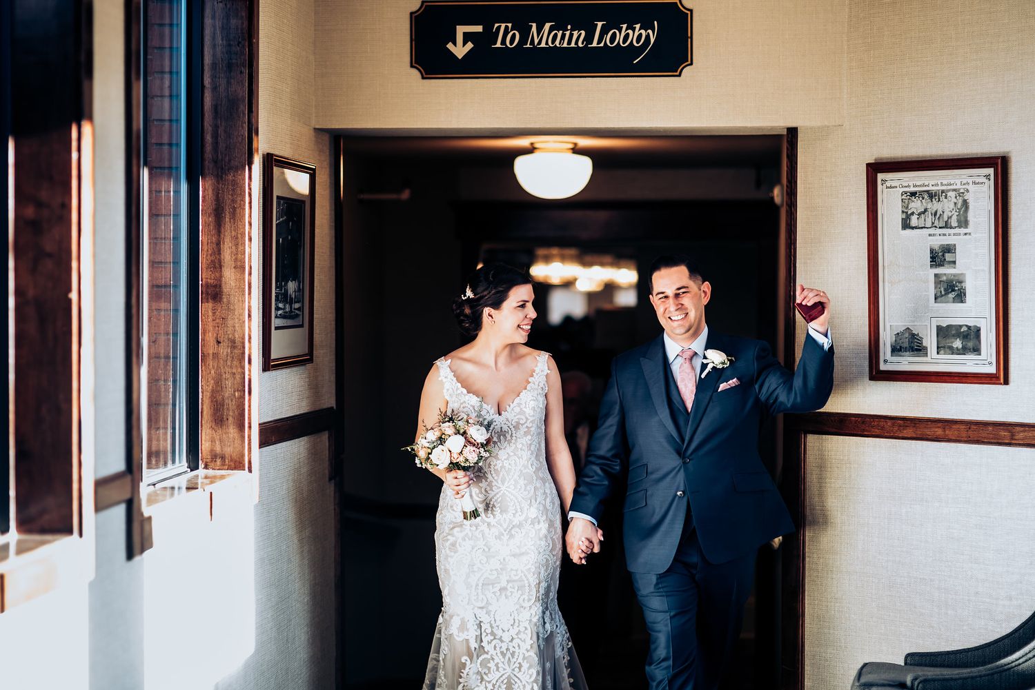 Couple walks through vintage hotel hallway beneath Main Lobby sign.