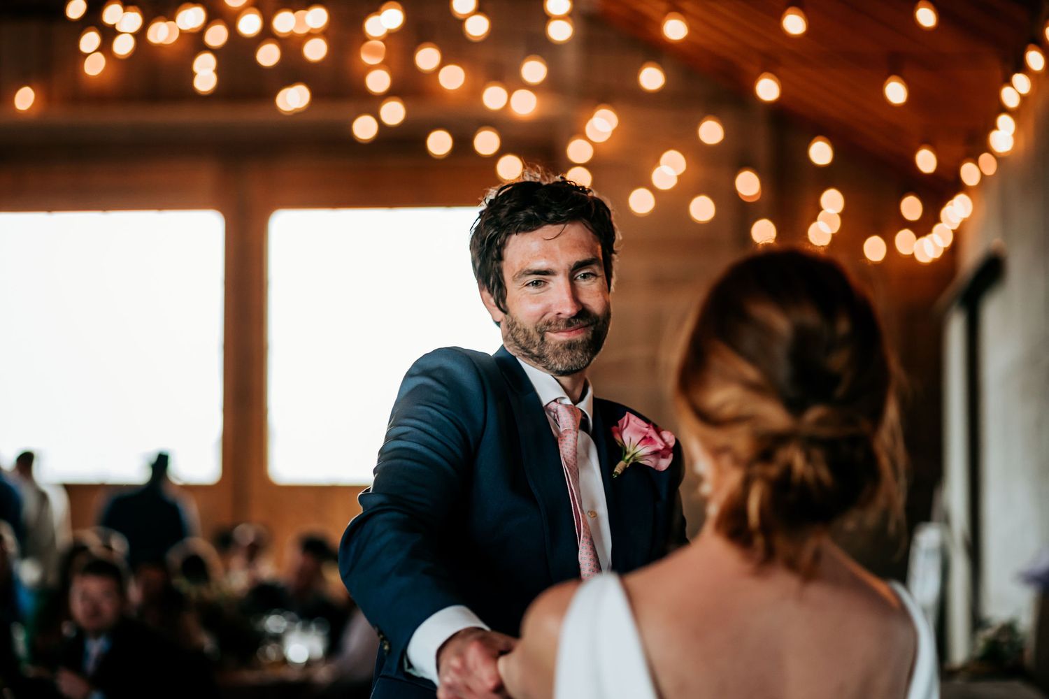 An intimate moment captured during a wedding first dance under warm lighting.