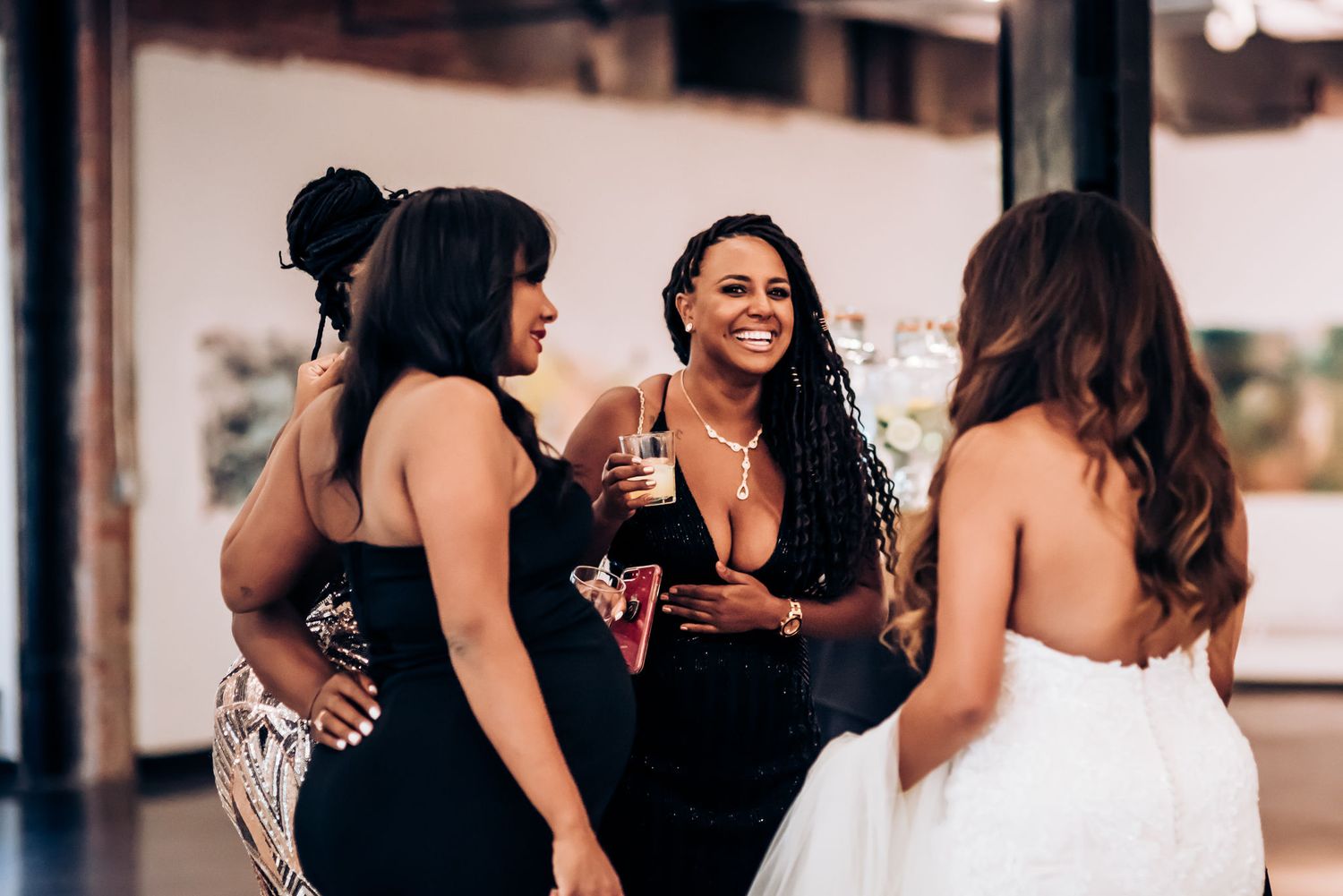 Wedding guests share drinks and laughter during reception celebration.