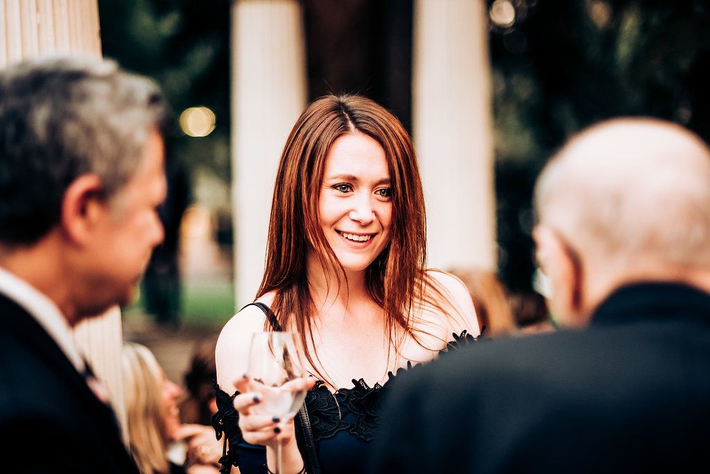 Guests engage in conversation during an elegant outdoor social gathering.