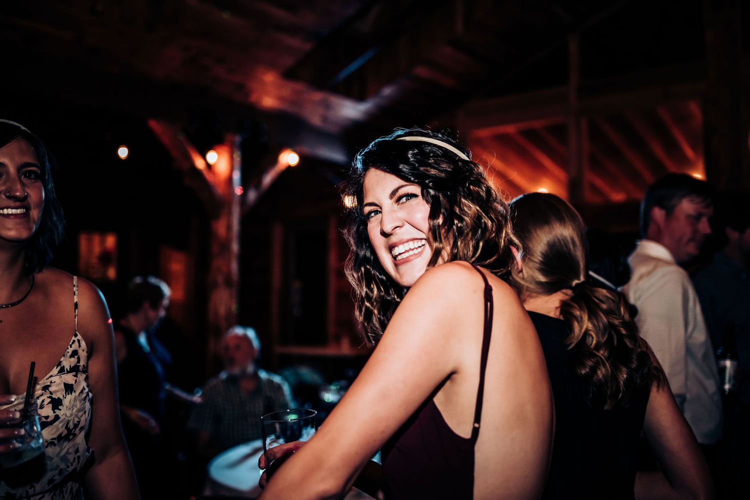 A guest enjoying the dance party atmosphere at a dimly lit wedding reception.