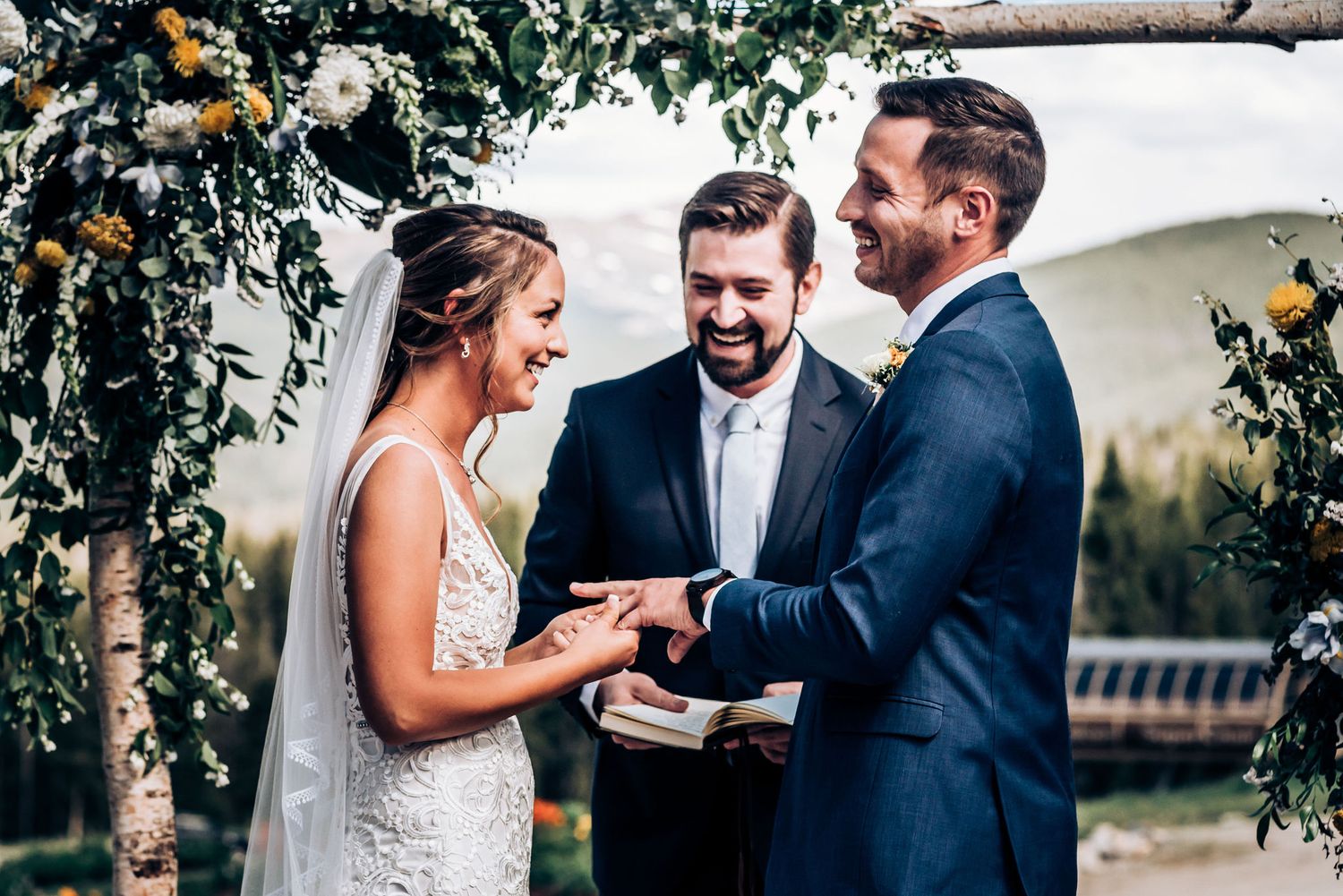 Wedding ceremony moment under floral arch with flower decorations.
