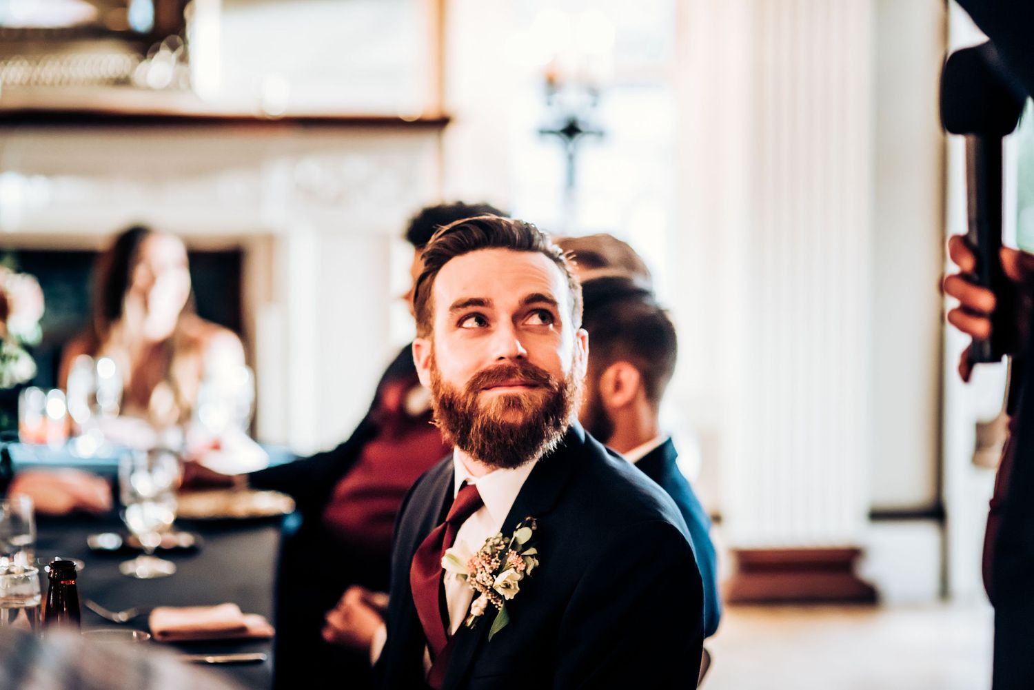 Wedding guest in formal attire at an elegant indoor reception venue.