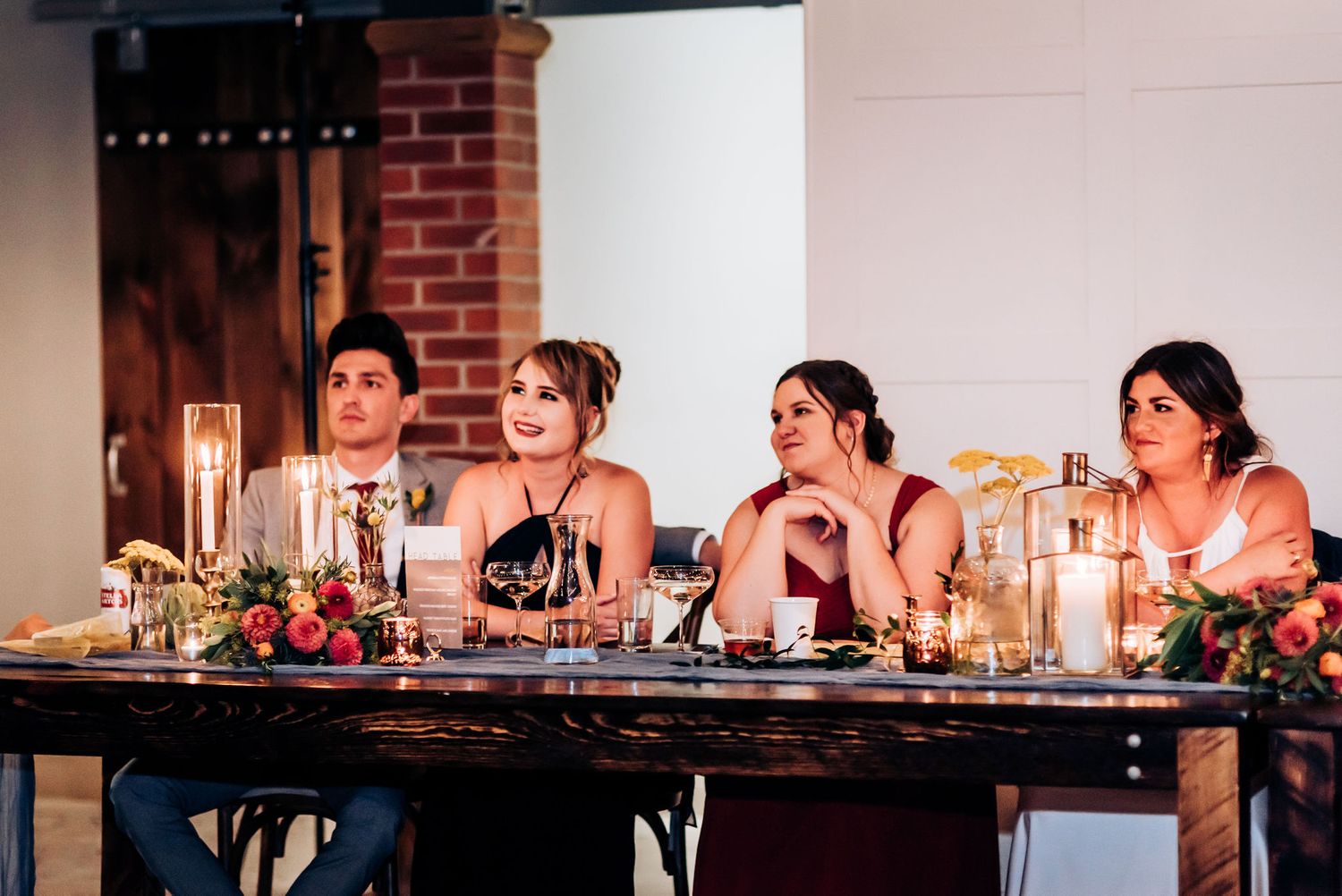 A group seated at an elegant table with candles and floral arrangements at a formal event.