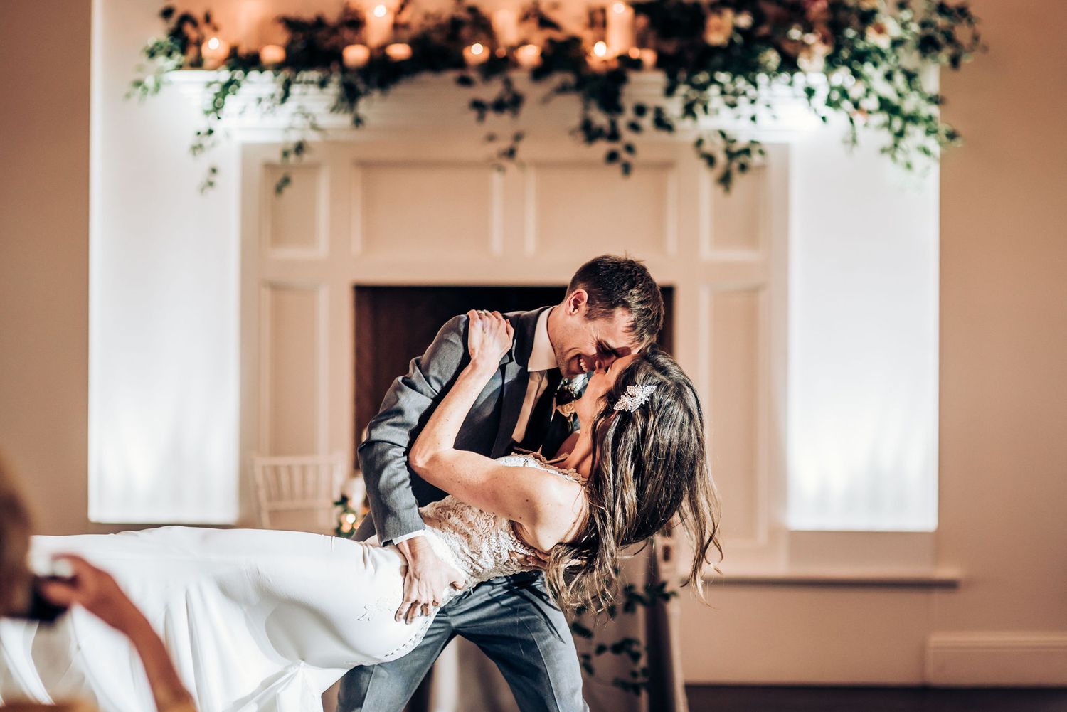 A romantic dip during the first dance at an elegant wedding venue with floral decorations.