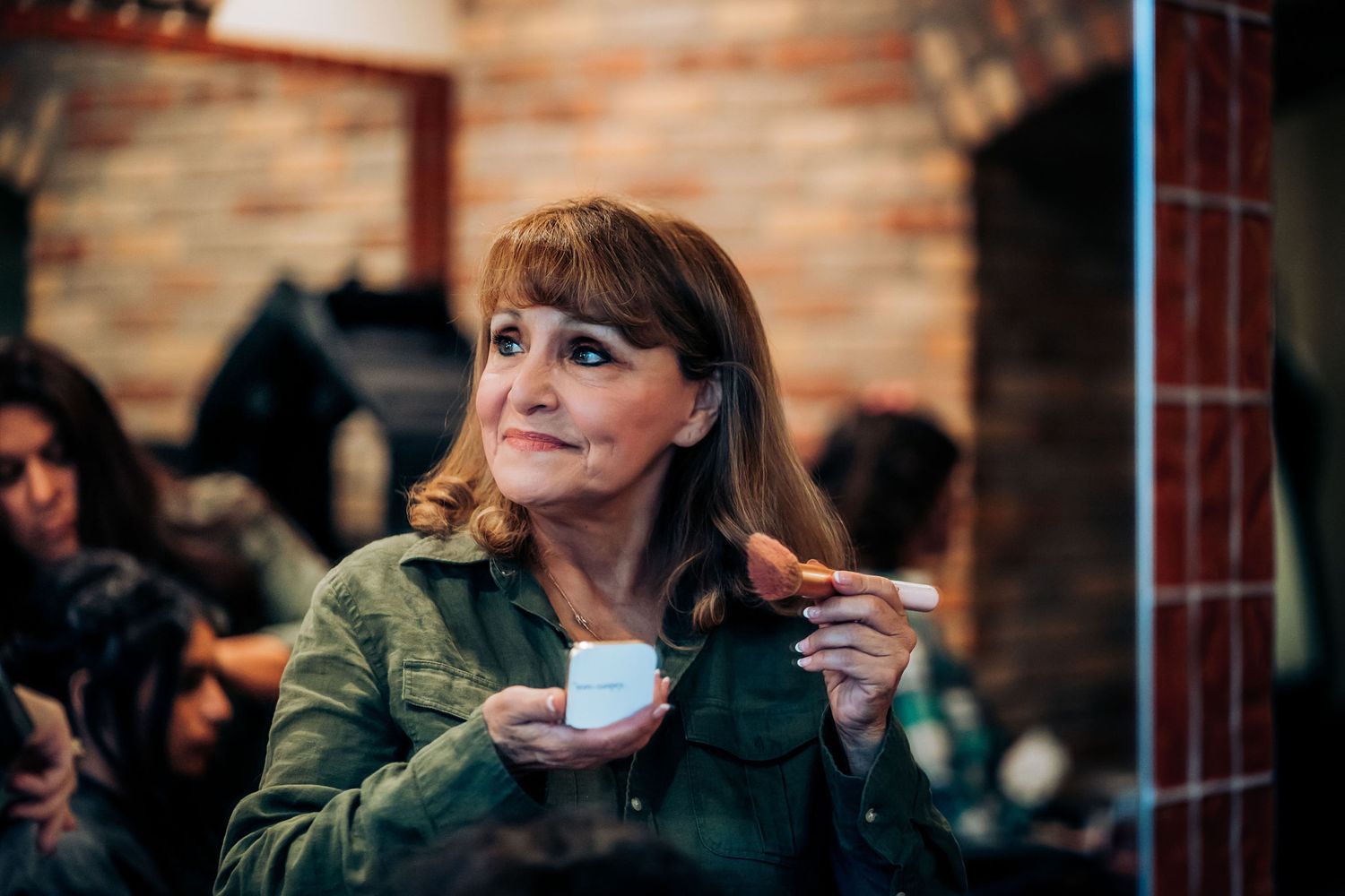 Someone enjoying a hot beverage and snack at a cafe with brick wall background.