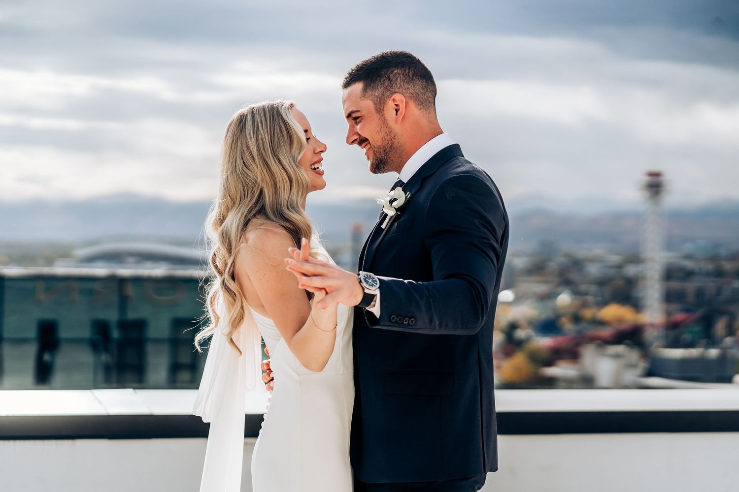 Elegant rooftop wedding portraits with cityscape backdrop.