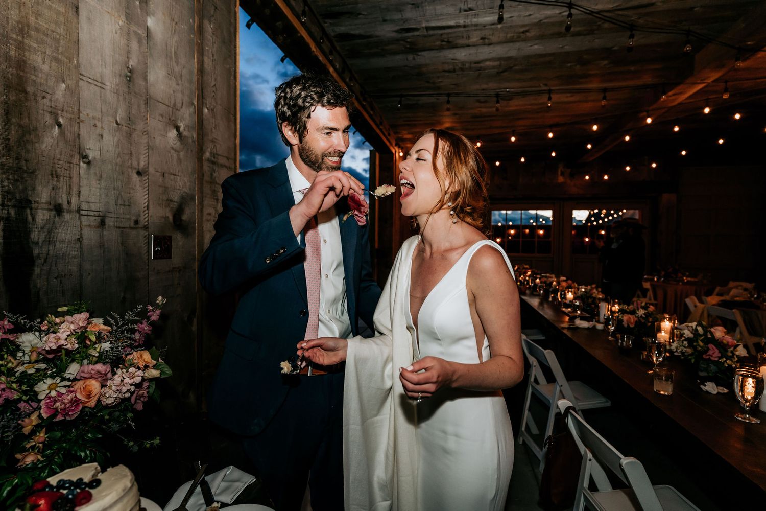 Reception celebration in rustic venue with romantic lighting and floral arrangements.