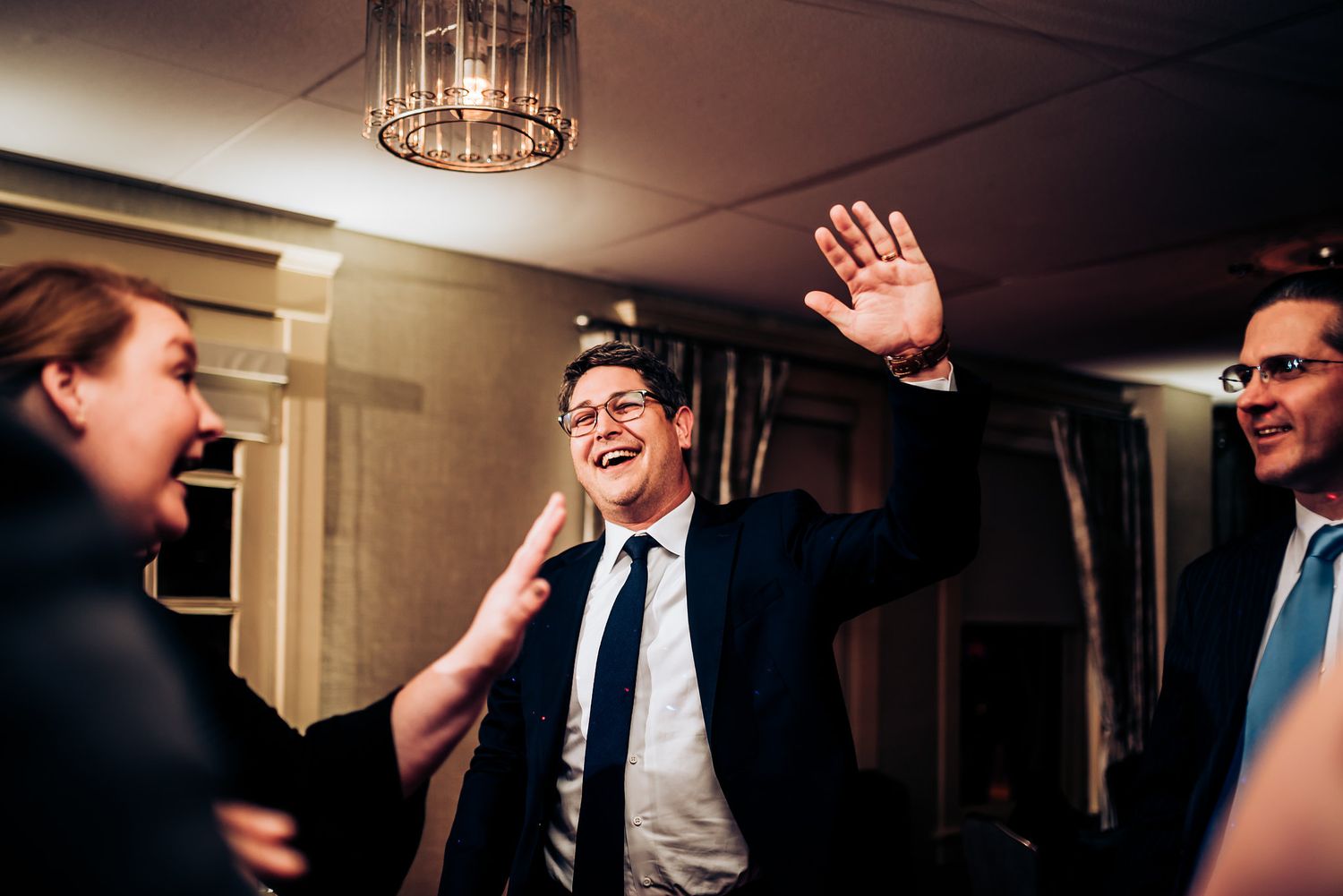 People enjoying themselves on the dance floor at an indoor celebration.