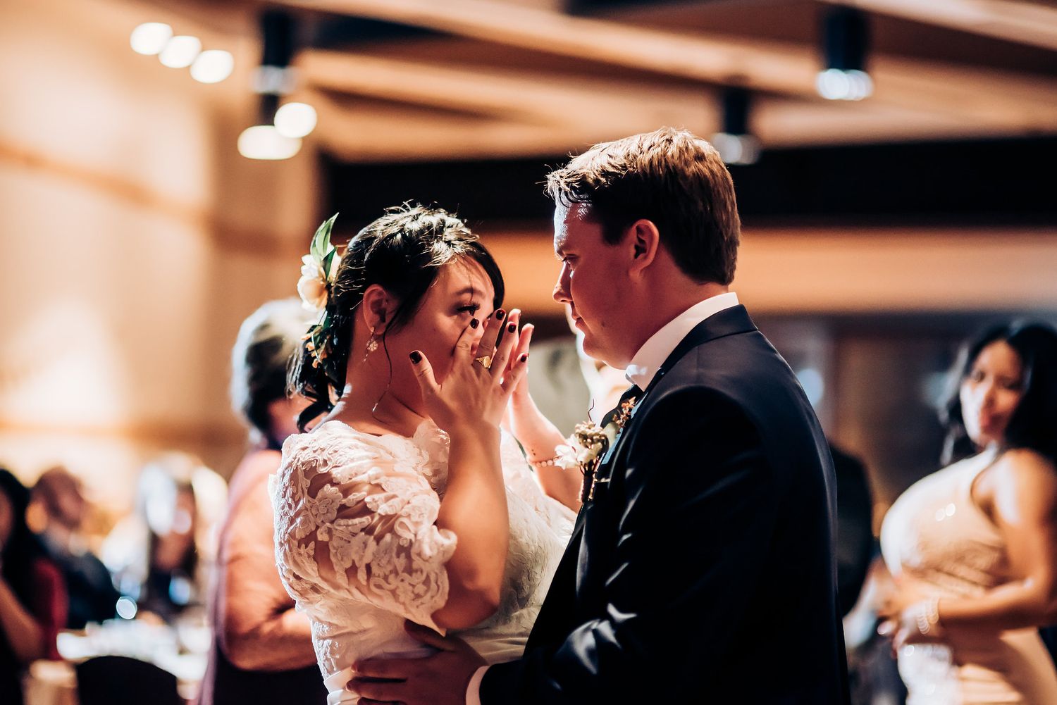 Touching moment captured between dancing newlyweds during their wedding reception.