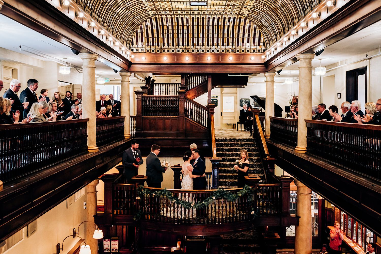 Architectural view of multi-level historic venue during wedding ceremony with wooden details.