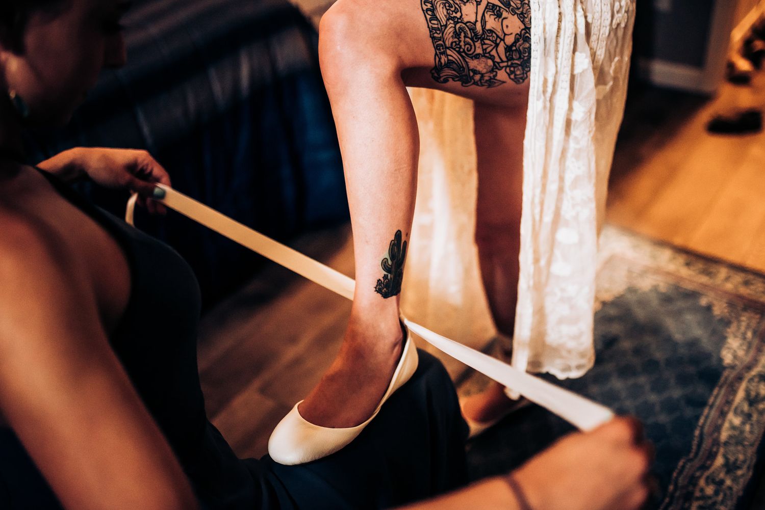 Close-up of white ballet flat being fastened with ribbon.