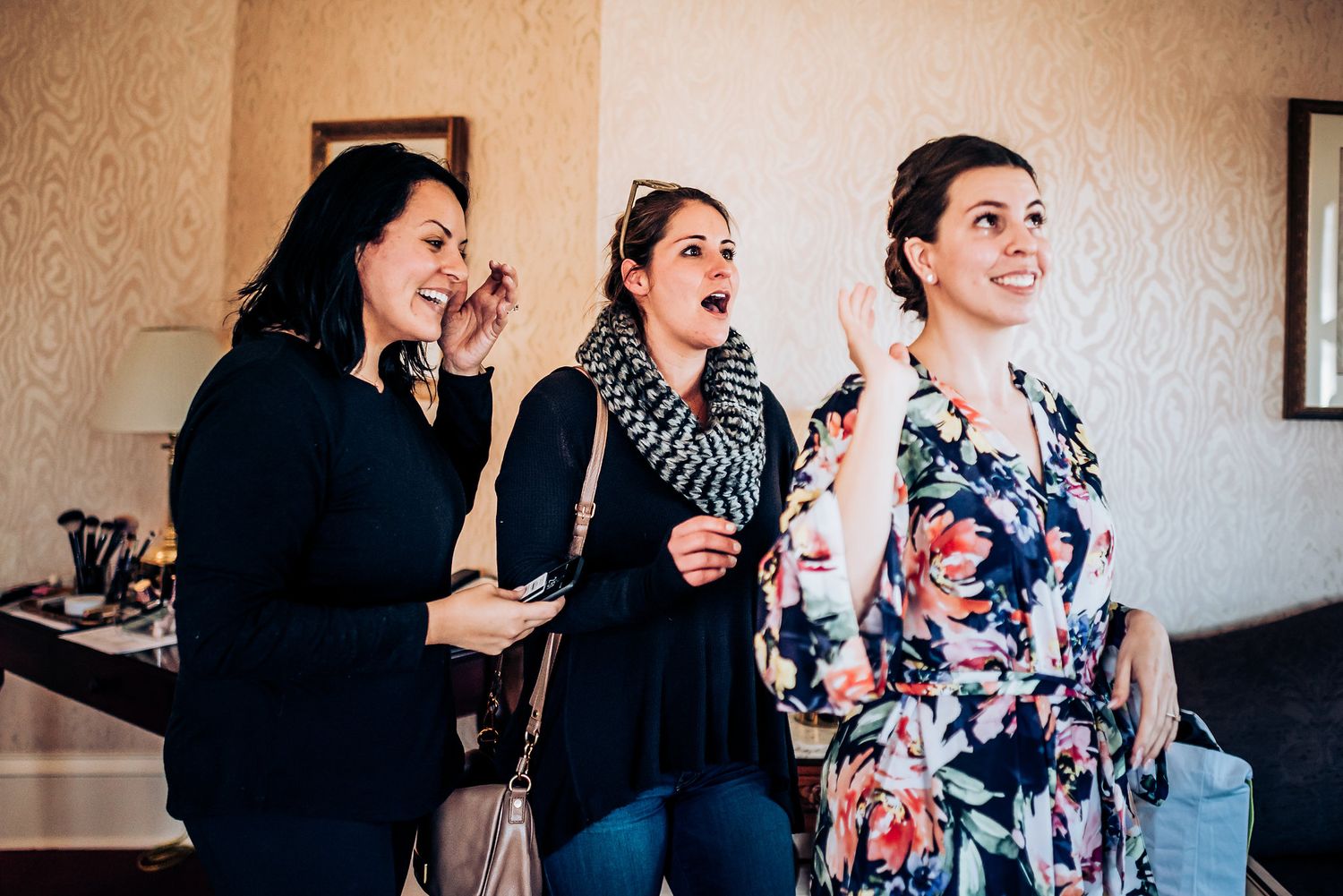 Three people share a candid moment of laughter and excitement during a special occasion.