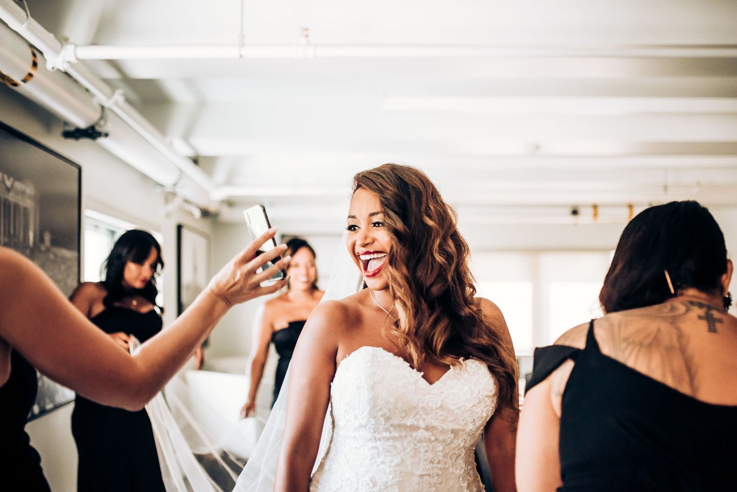 A joyful moment captured during wedding preparations with makeup being applied.
