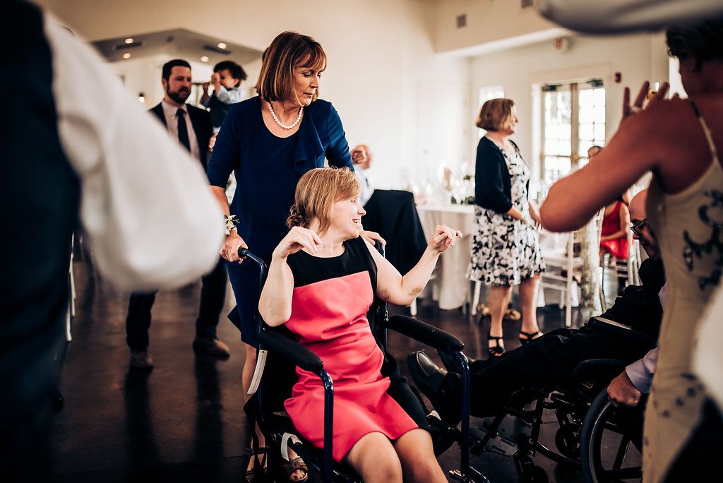 Guests dancing and celebrating at indoor event with wheelchair-accessible space.