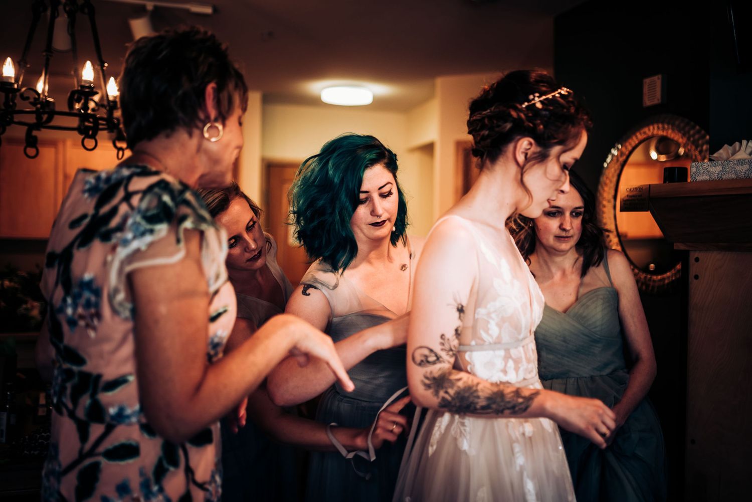 Wedding party helping with final bride preparations in vintage-style room.