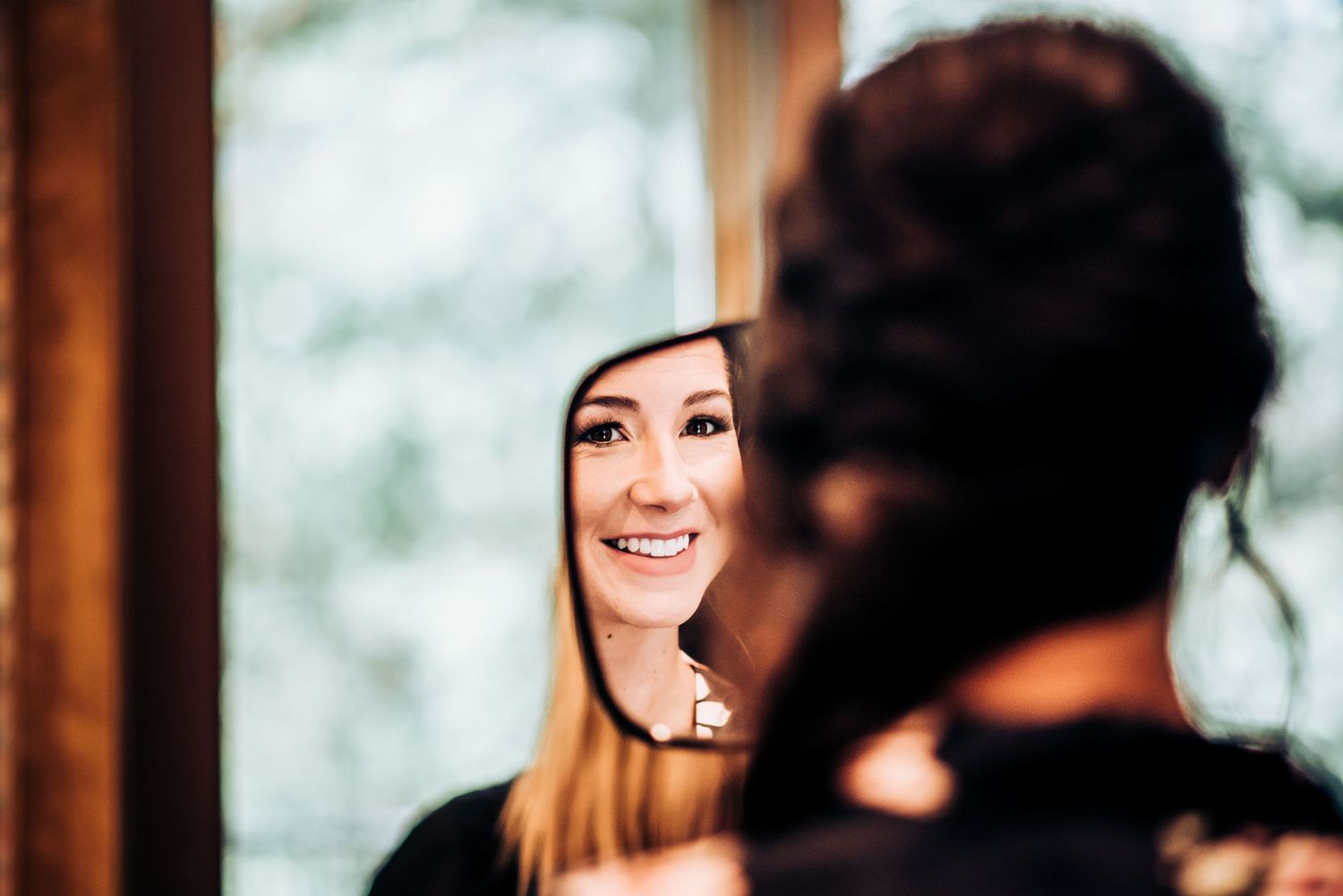 A candid moment captured during wedding day preparations with warm lighting.