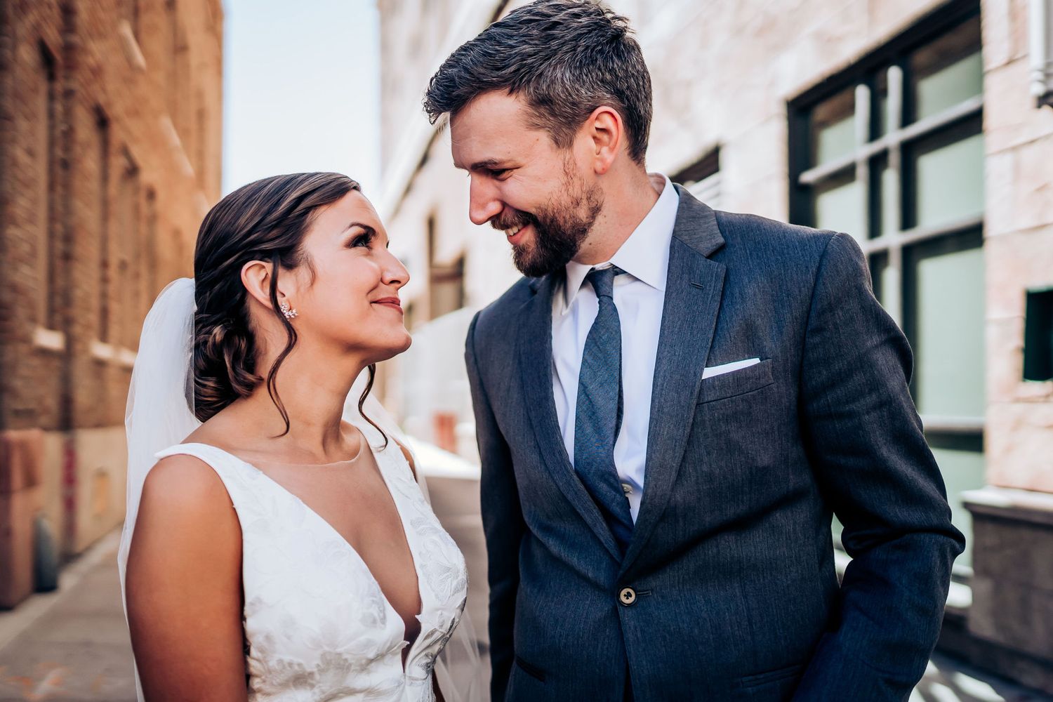 An intimate wedding portrait moment captured against an industrial brick backdrop.