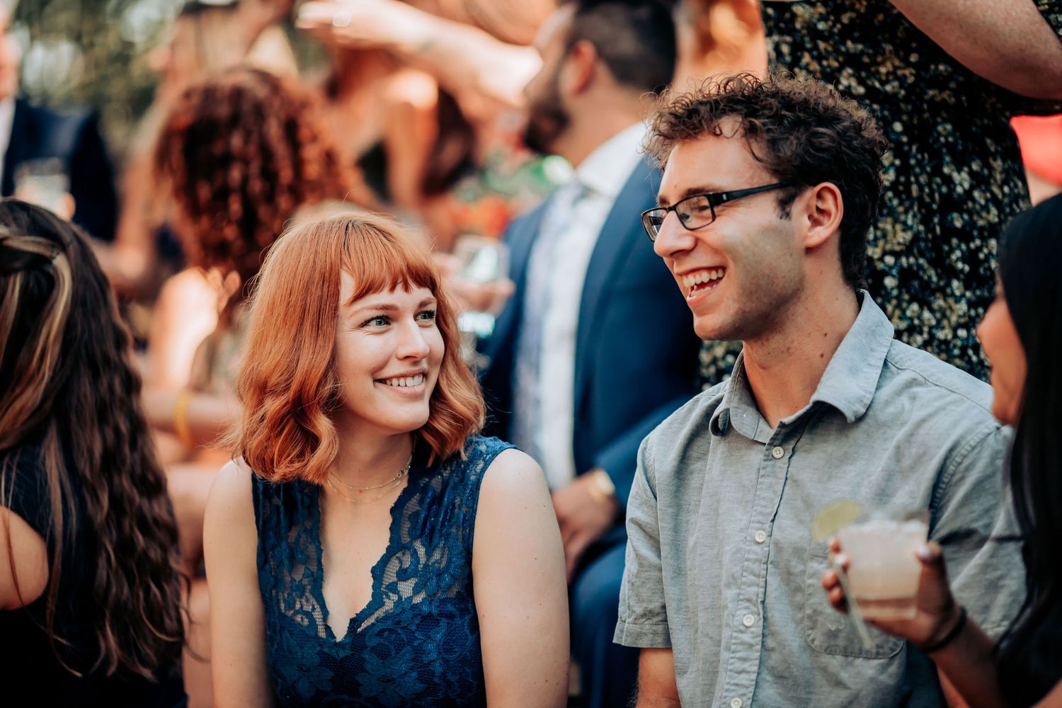 A candid moment of laughter and conversation at an outdoor social gathering.