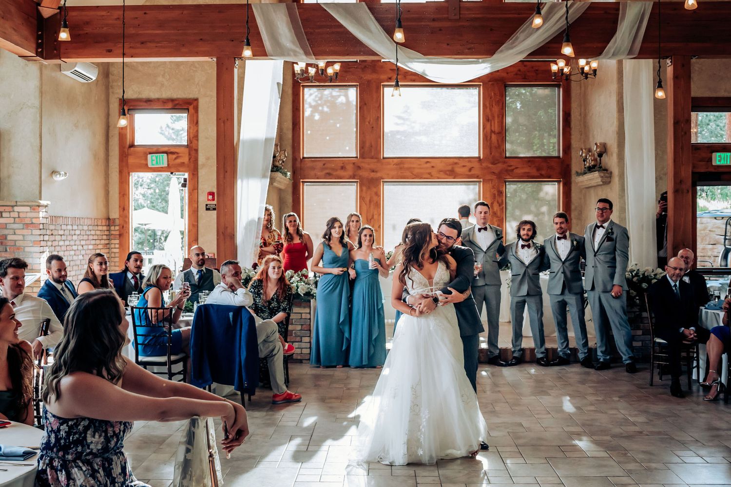 Wedding ceremony in progress at rustic venue with exposed beams and natural lighting.