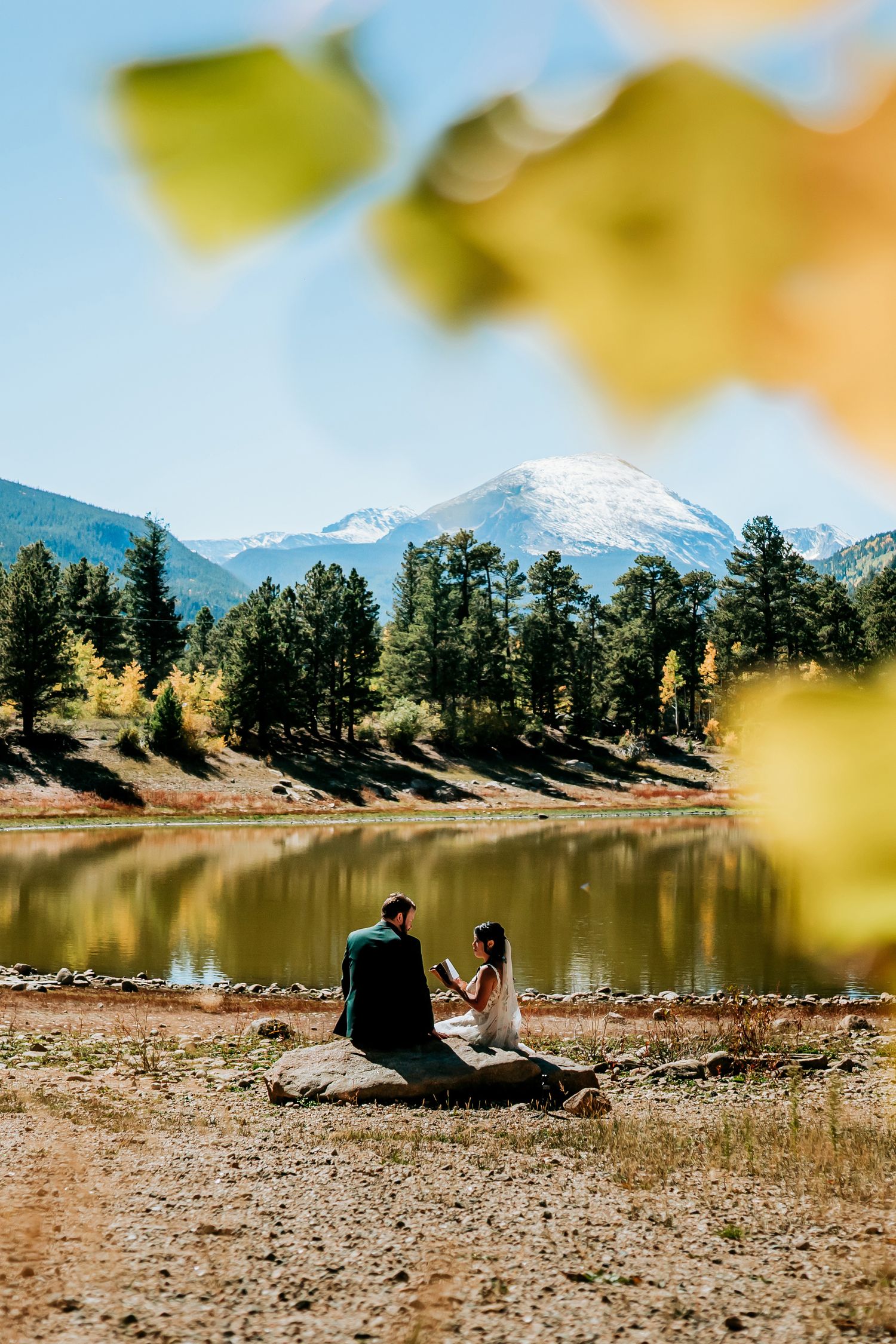 Peaceful lakeside moment with mountain views and pine trees in the background.