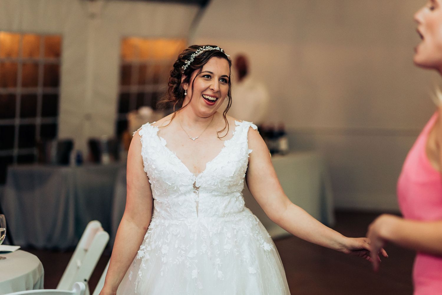 Joyful moment during wedding reception with elegant lace gown.