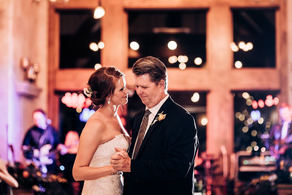Romantic first dance at wedding reception with soft lighting and string lights creating intimate atmosphere.