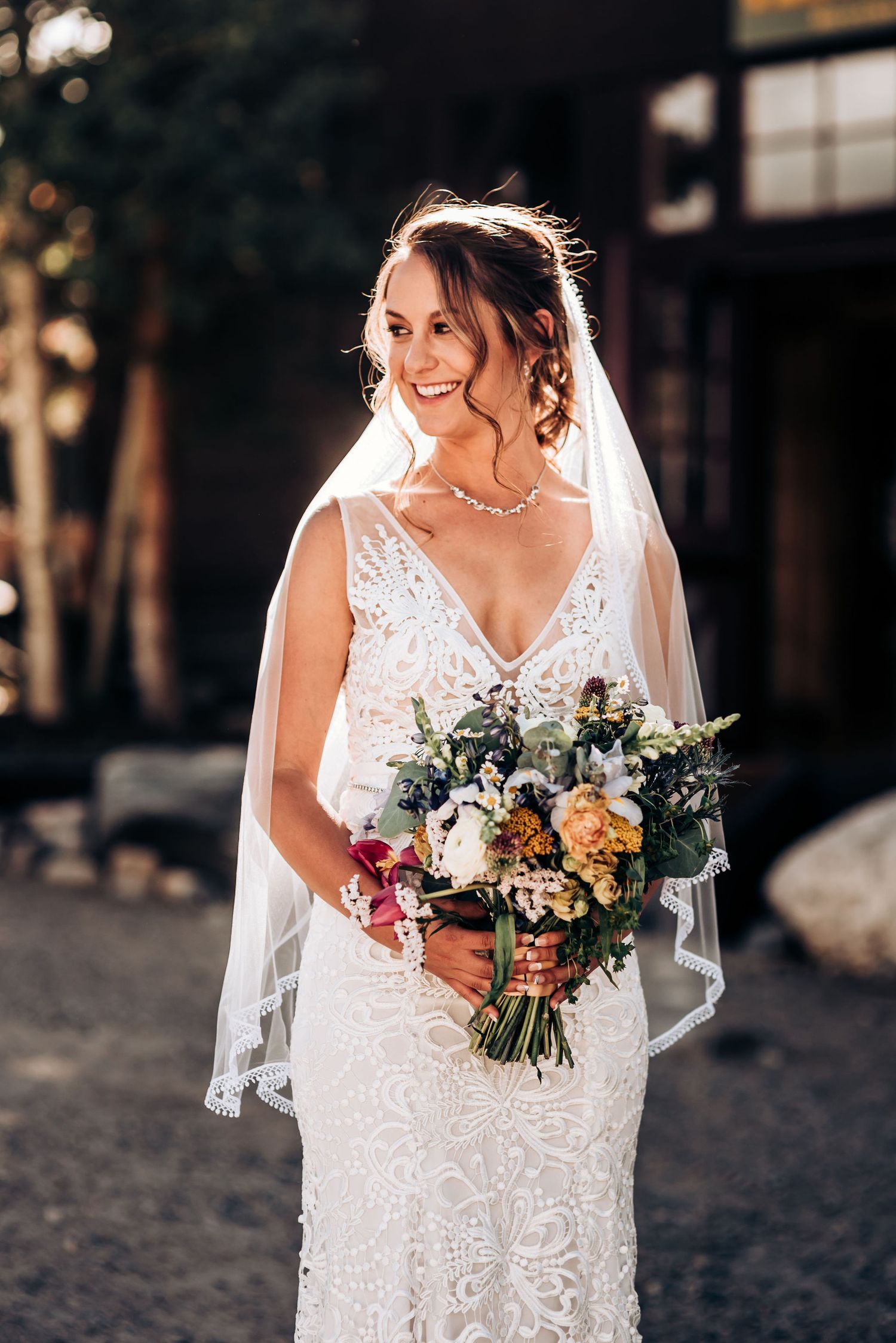 Joyful bridal portrait with natural bouquet featuring peach and cream florals.