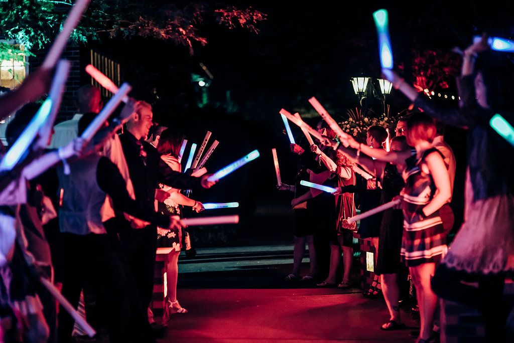 Crowd holding colorful LED light sticks creating a vibrant nighttime display.