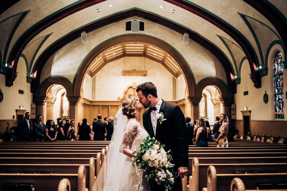 Elegant church wedding ceremony in a grand cathedral with vaulted ceilings and stained glass windows.