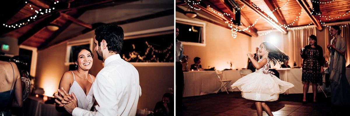 Wedding guests dance and celebrate under string lights at an indoor venue.