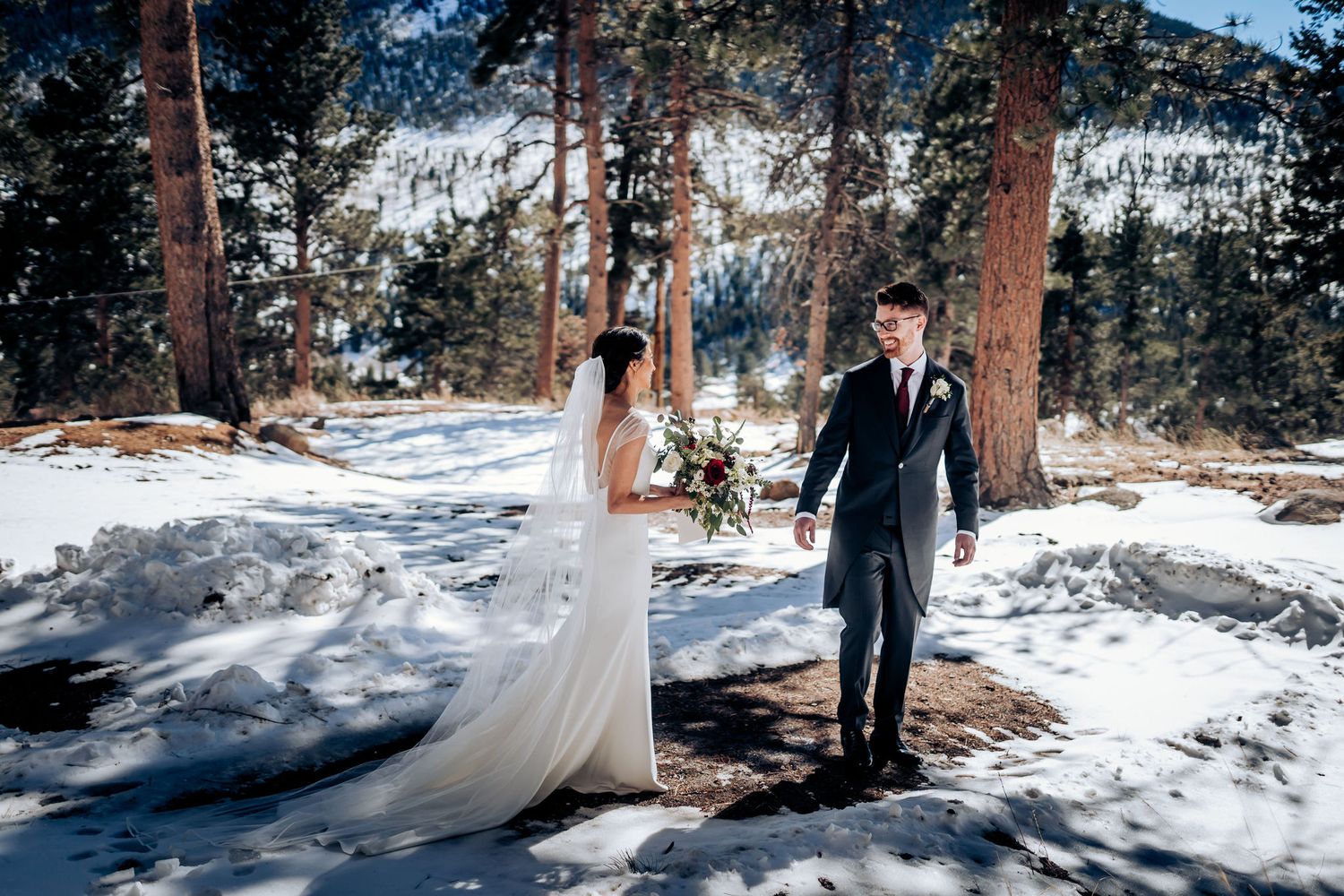 A couple share their first moments as newlyweds in a stunning snowy mountain setting.