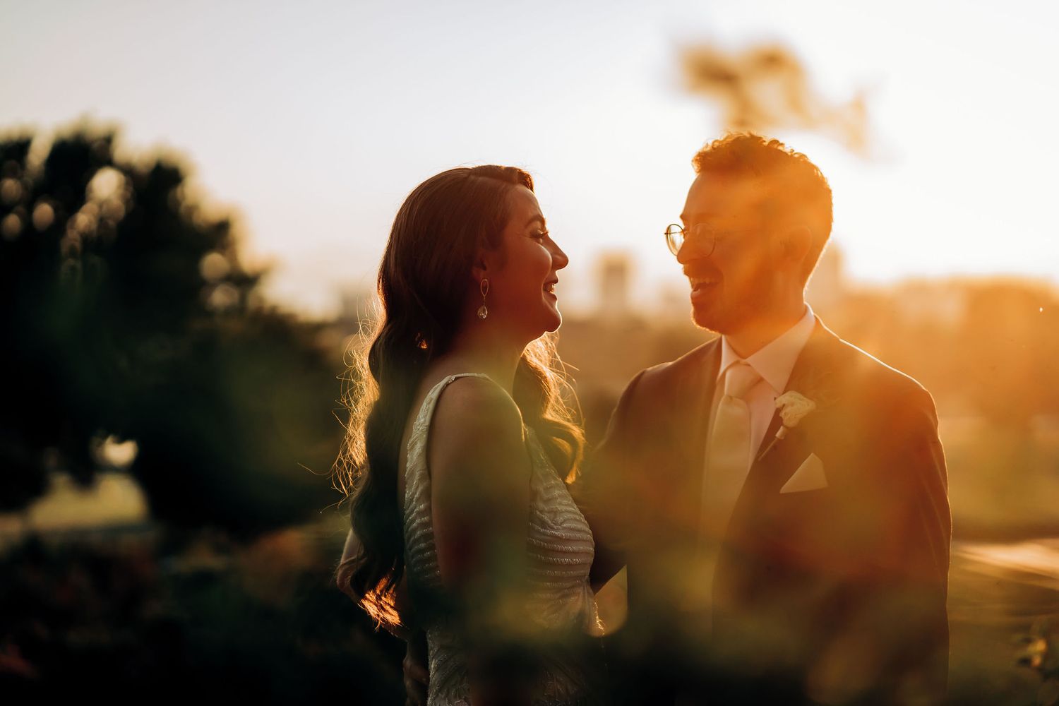 Romantic silhouetted couple sharing a moment at sunset during their wedding.