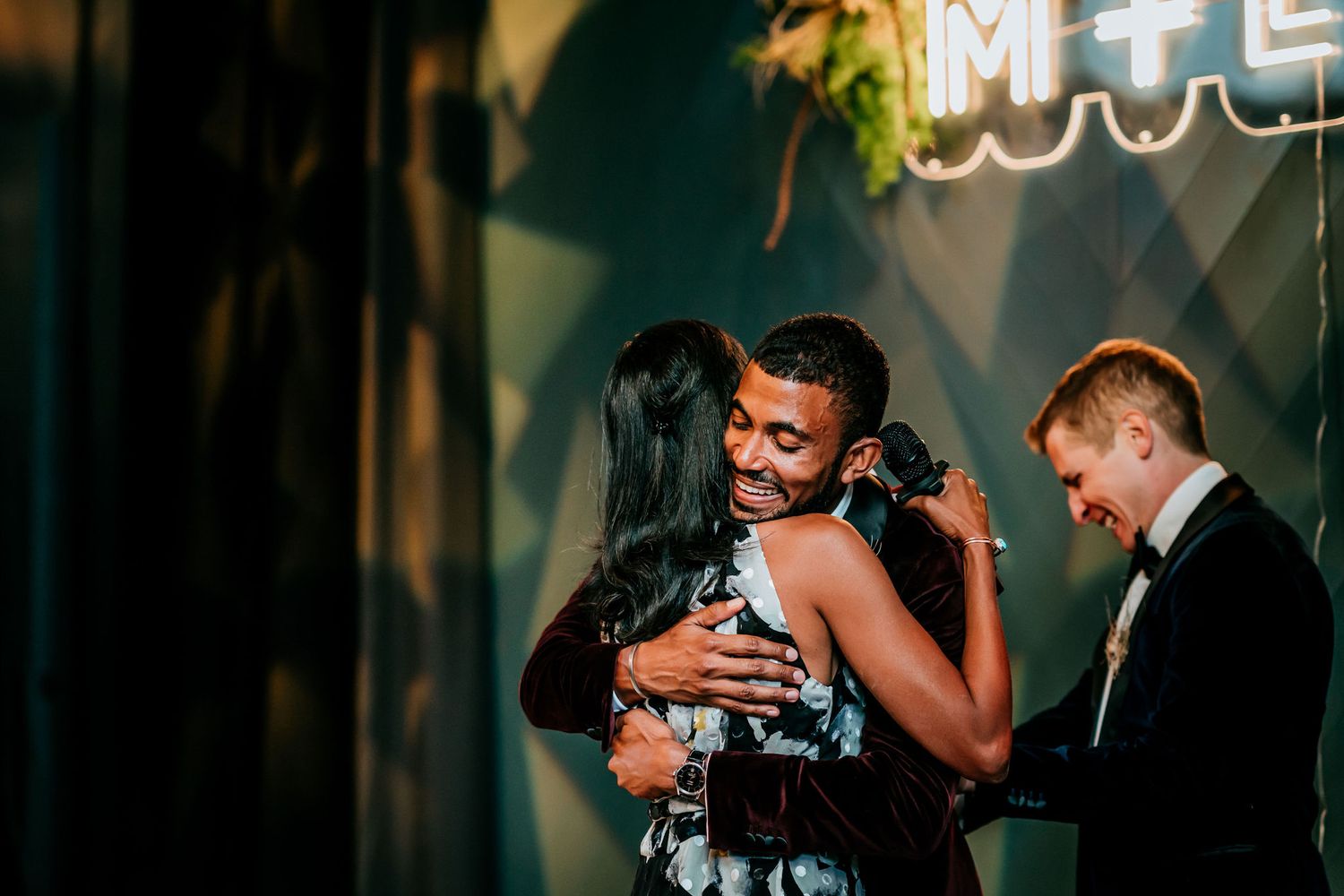 Emotional dance moment captured during wedding reception under dim lighting.