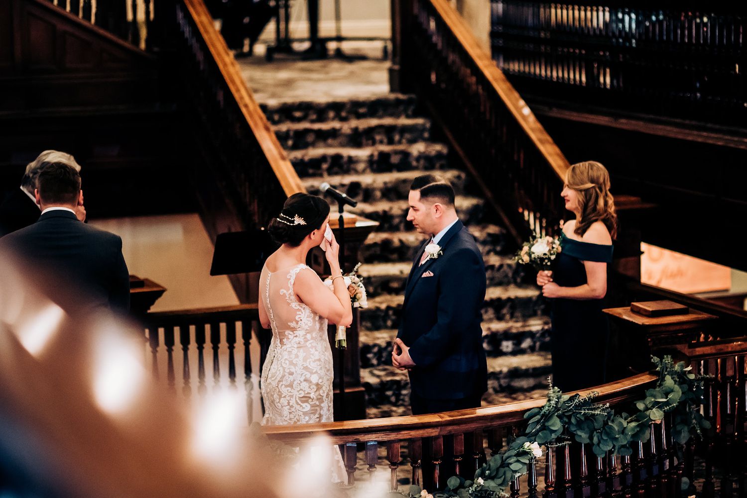 A special ceremony taking place on an elegant wooden staircase with ornate details.