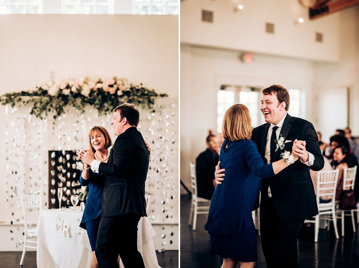 Guests dancing together at a wedding reception decorated with a floral arch and twinkling lights.
