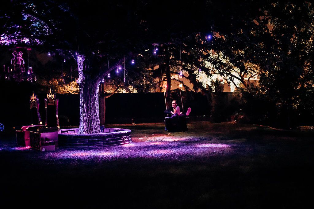 Enchanting garden illuminated with purple lights and glowing decorative elements creating a magical nighttime atmosphere.