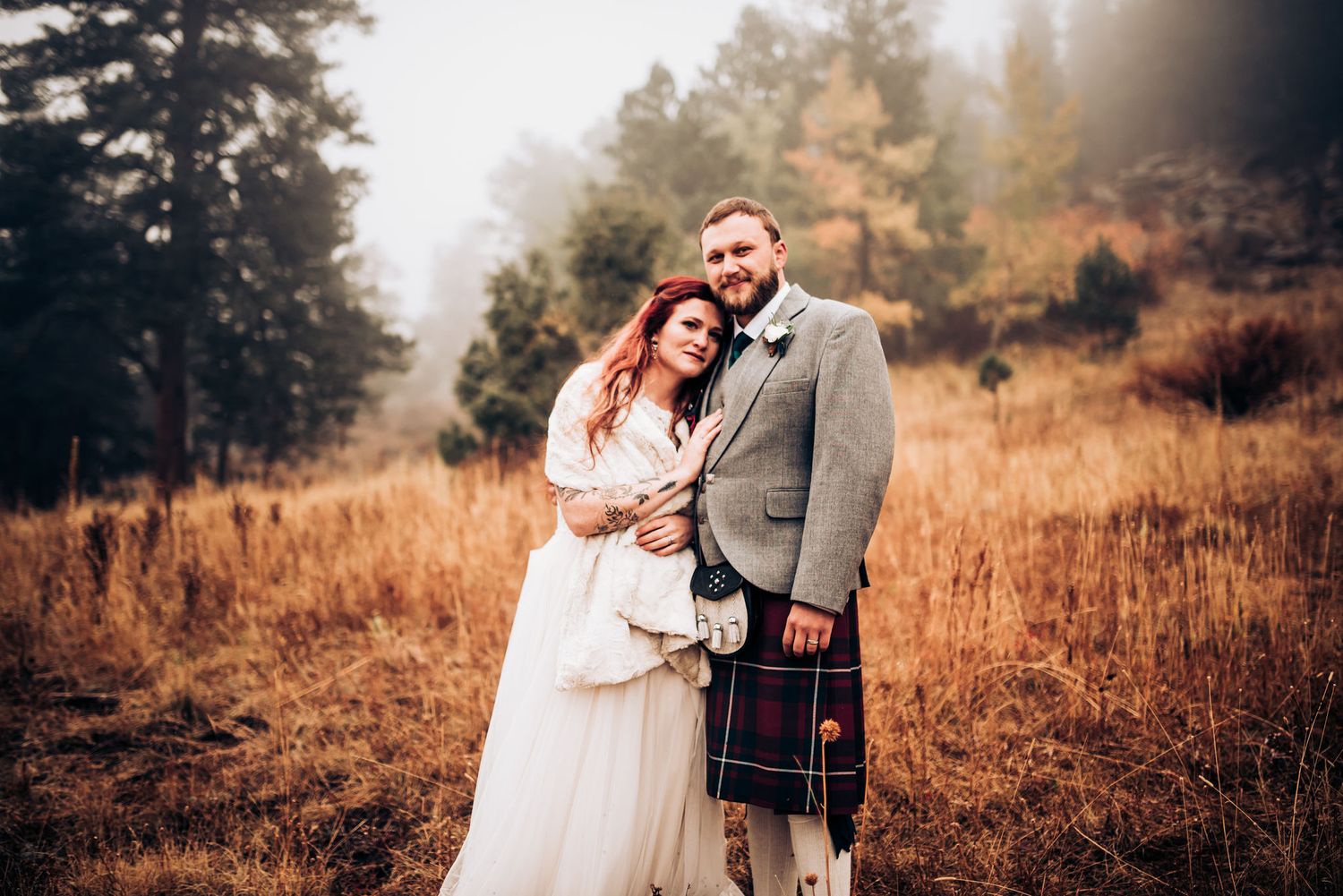 Traditional Scottish wedding portrait with mountain backdrop and autumn colors.