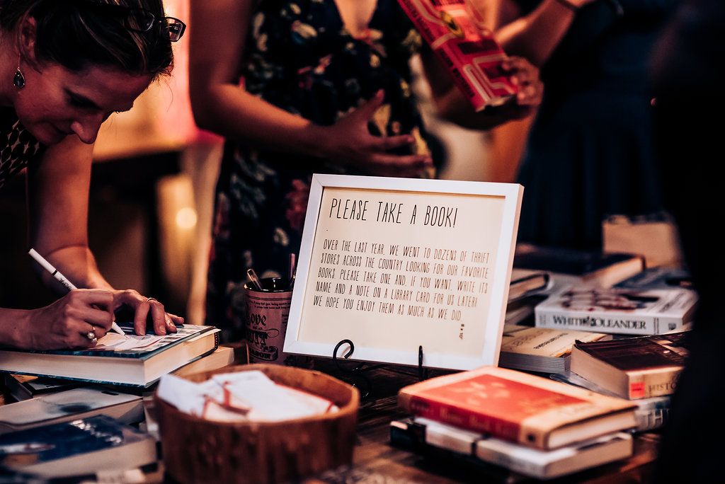 Wedding detail shot of decorative signage and table settings at reception.