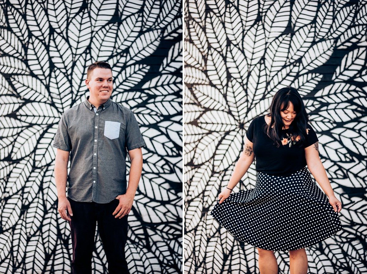 Stylish couple poses separately against geometric leaf pattern wall mural.