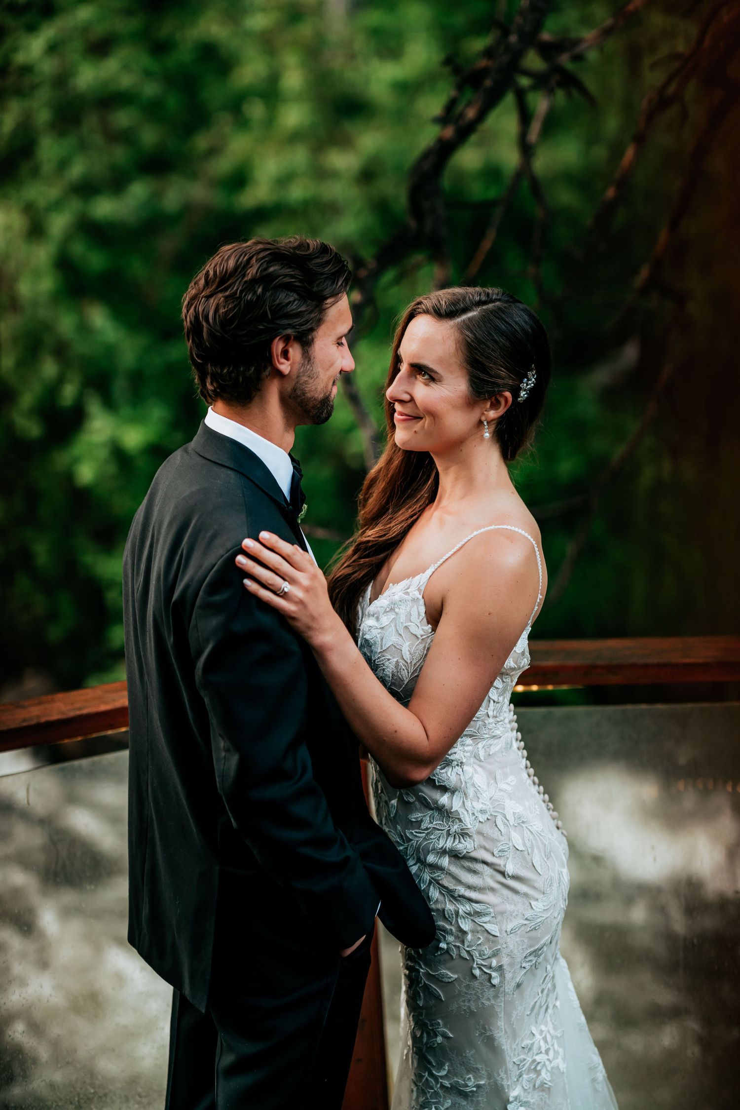 A romantic moment captured between two people in formal attire against a lush green background.