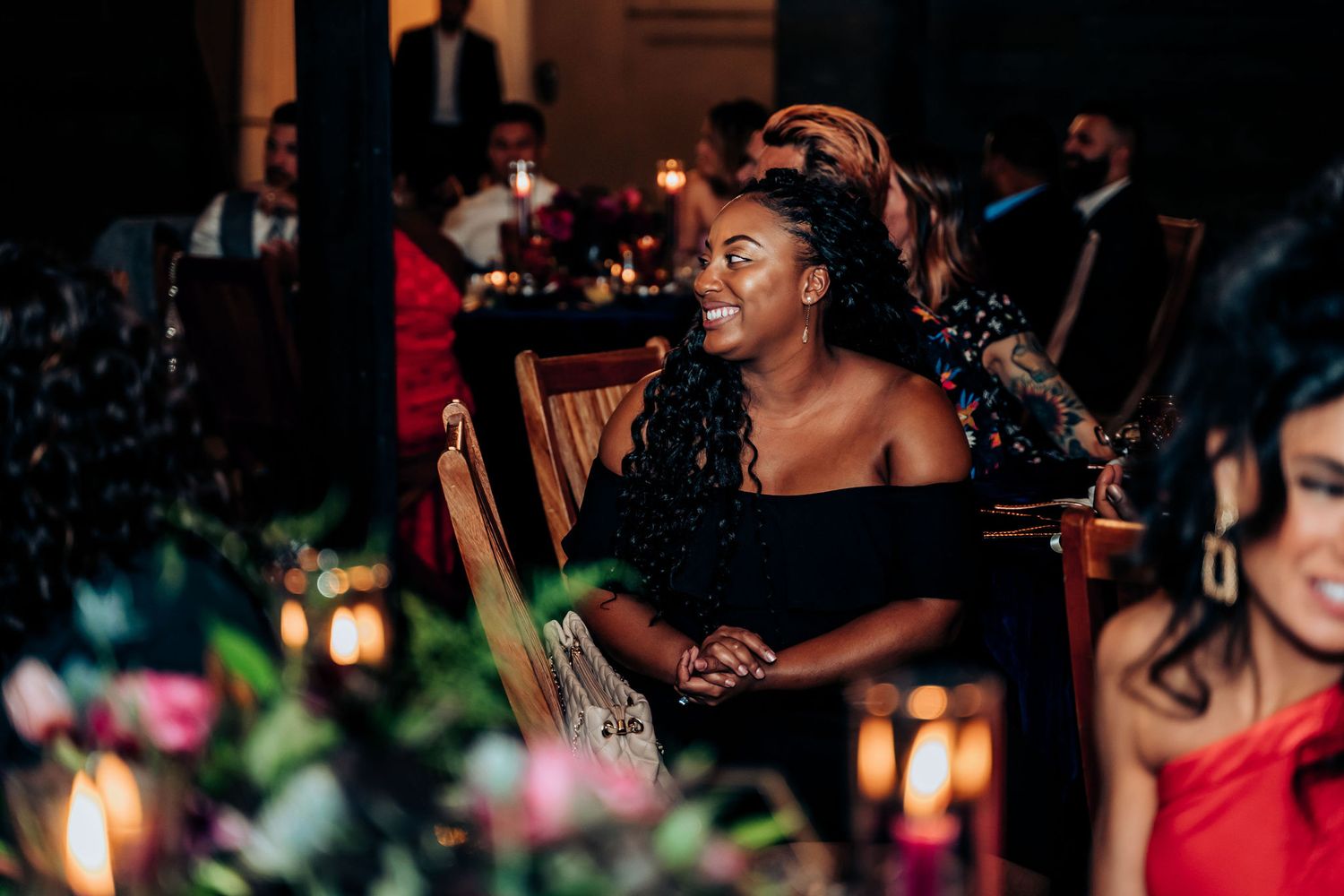 A guest enjoys the wedding reception in candlelight at an elegantly decorated table.