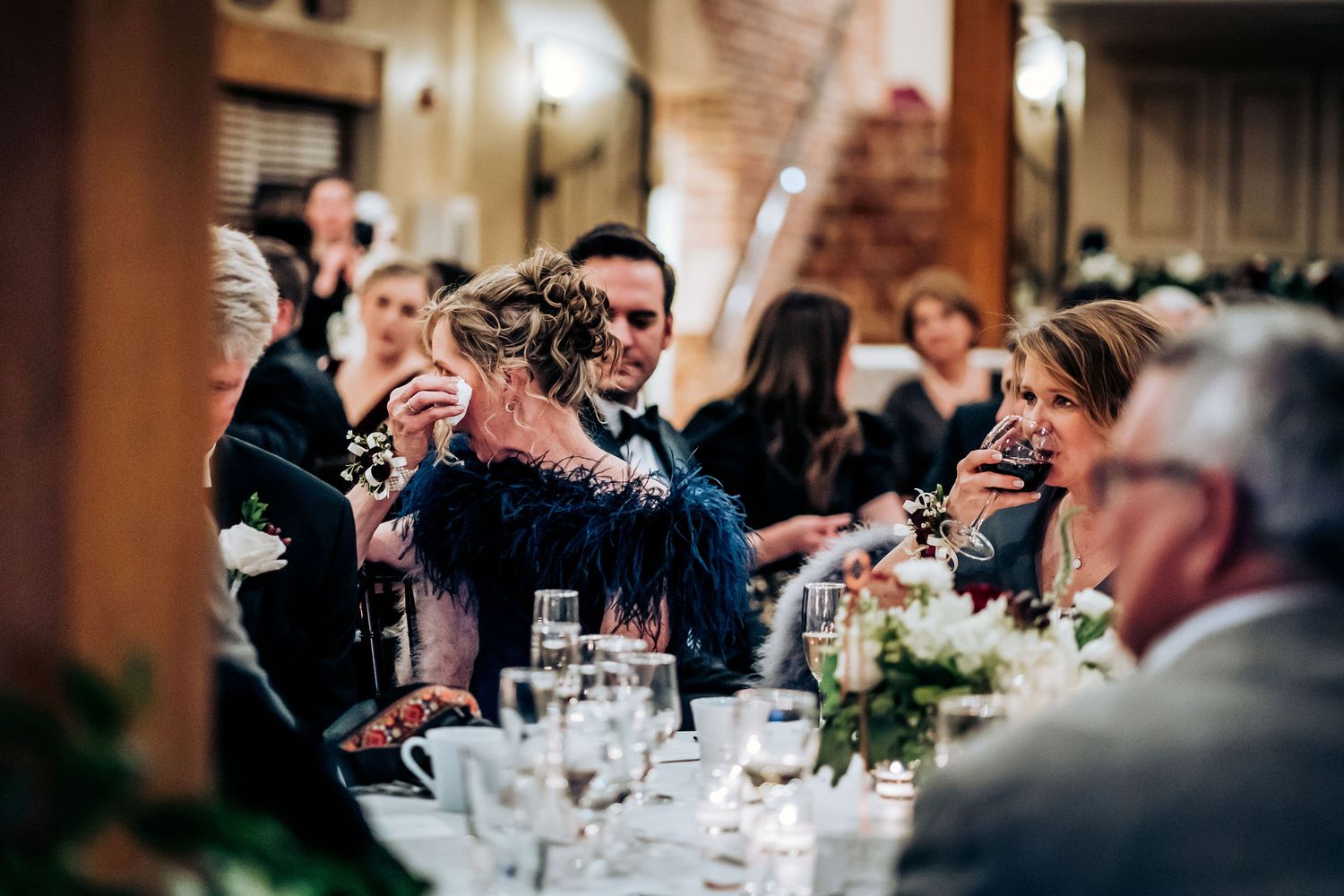 Candid reception moment of guests celebrating at tables during wedding dinner.