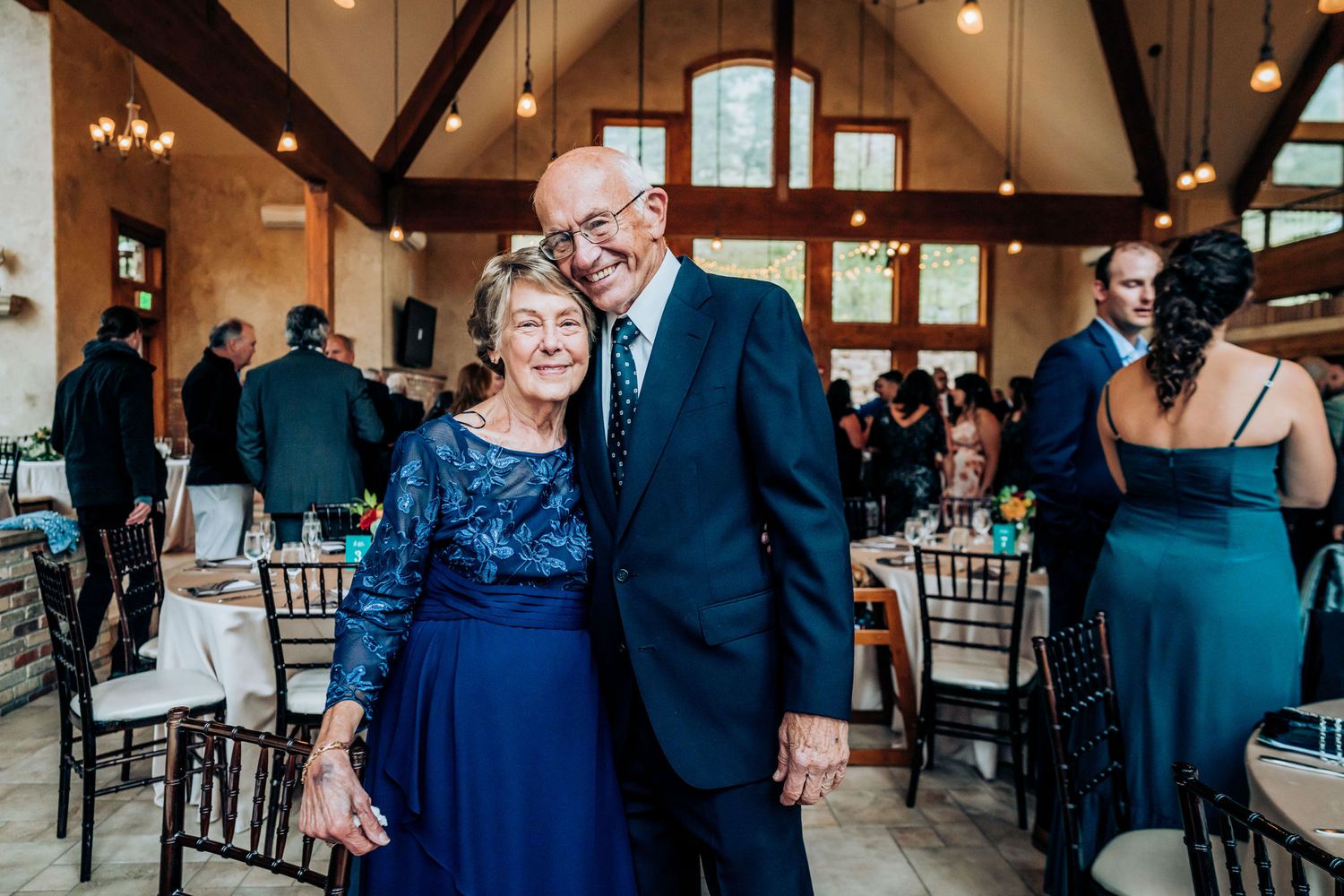 Elegantly dressed couple in matching navy blue attire dancing at a formal event.