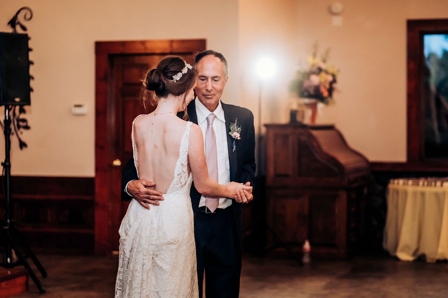 Intimate dance moment during wedding reception in elegant indoor venue.