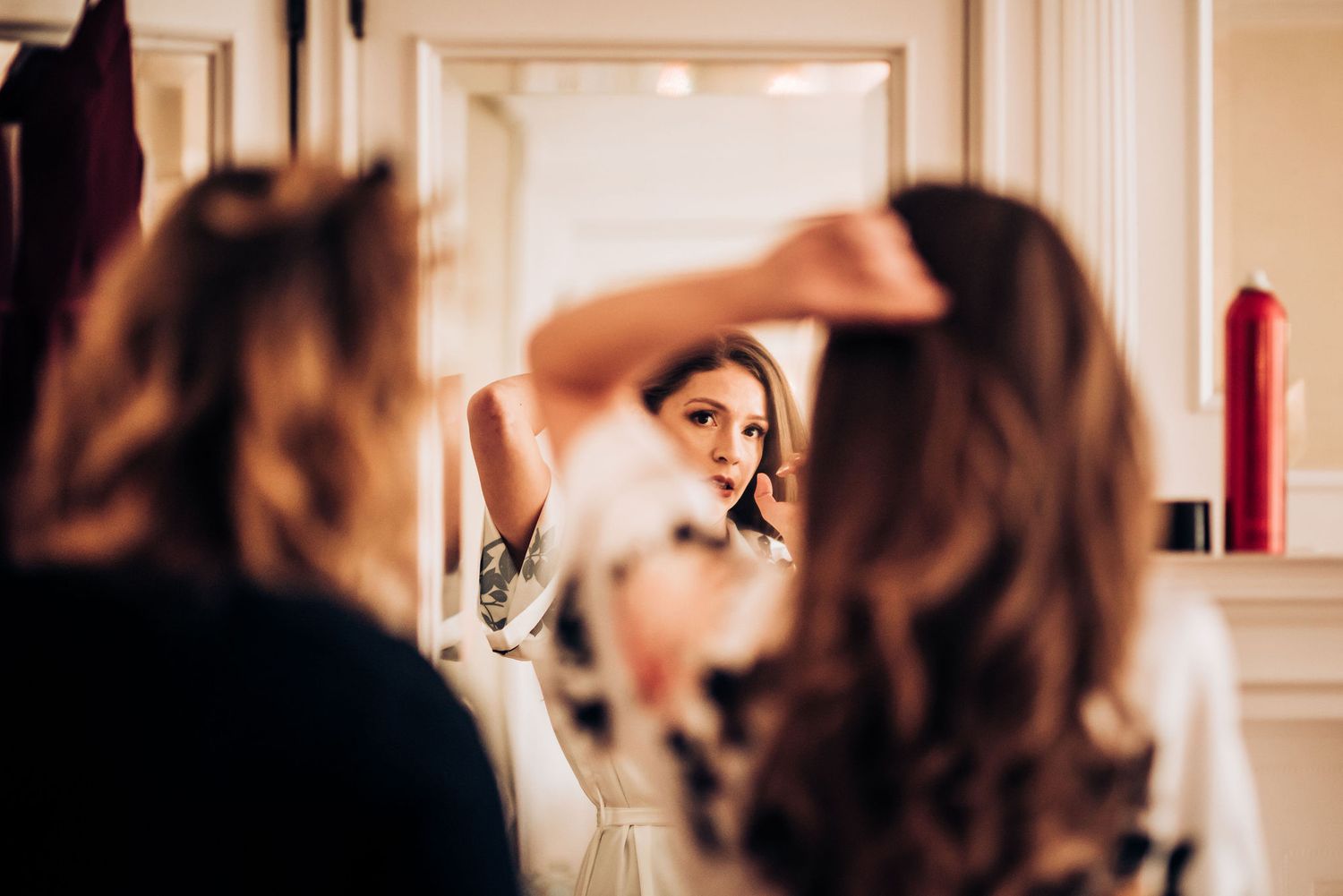 Getting ready scene reflected in mirror during wedding preparations.