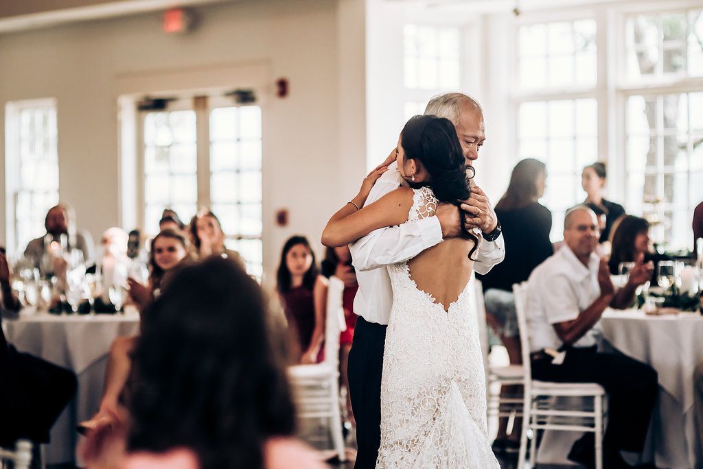 Wedding guests embrace on the dance floor during a reception celebration.