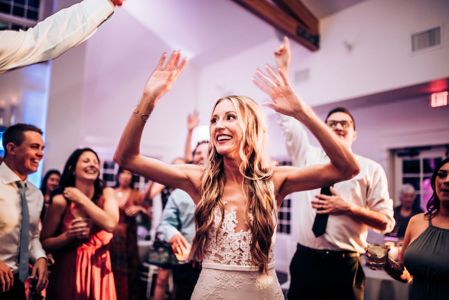 A celebration on the dance floor with people dancing and raising their hands in joy.